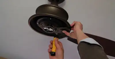 Electrician installing ceiling fan mounting bracket and fixture in Indianapolis, IN