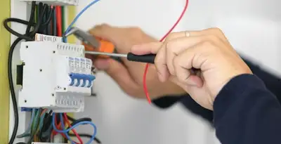 Electrician installing and adjusting circuit breakers in an electrical panel in Indianapolis, IN