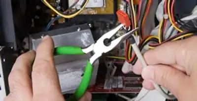 Licensed electrical contractor performing electrical repair with tools in Greenwood, IN