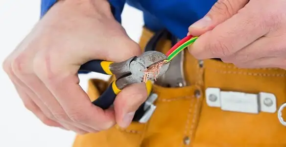 licensed electrician securing electrical wiring with professional tools during service work in Indianapolis, IN