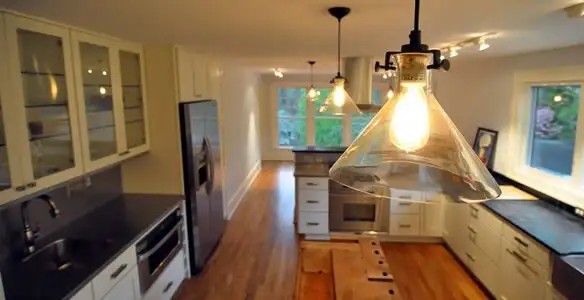 Residential electrician installing modern indoor light fixture in a home in Indianapolis, IN