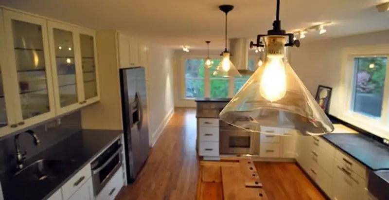Residential electrician installing modern indoor light fixture in a home in Indianapolis, IN
