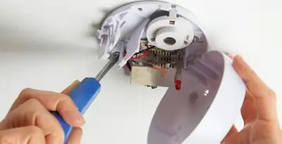 Certified technician wiring smoke detector during installation in Indianapolis, IN